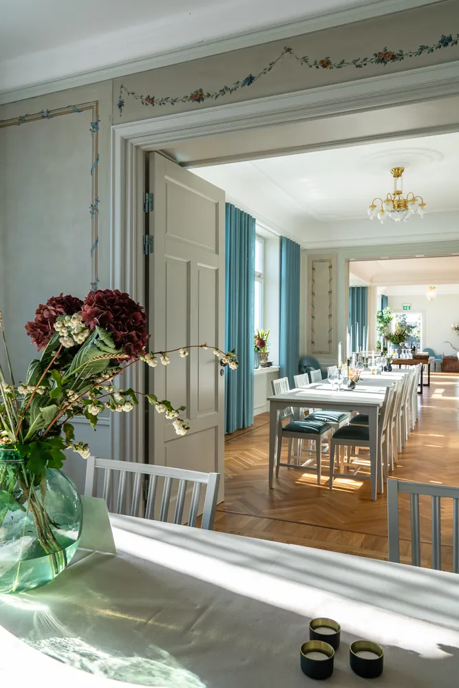 Dukat bord med blommor och vinglas vid fönstret